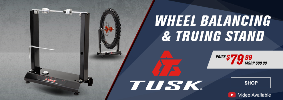Tusk Wheel Balancing and Truing Stand, Price $79 and 99 cents, MSRP $99 and 99 cents, Tusk logo, video available, a Tusk Truing stand with another one in the background that has an MC tire and wheel on it, link, shop