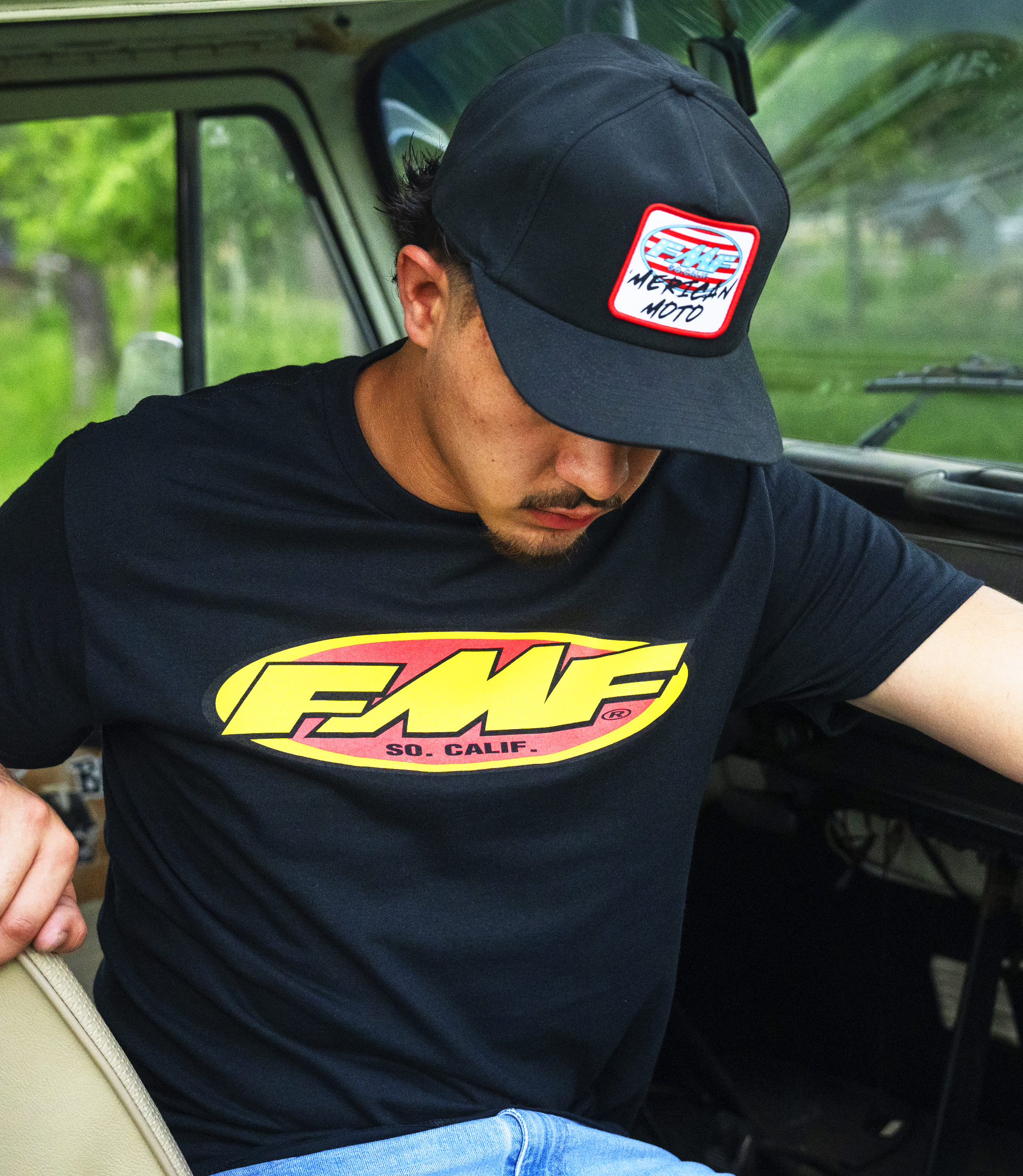 Man getting out of a truck with an FMF hat and shirt