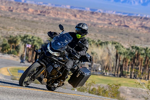 A rider on the road taking a turn in the MSR Cryomesh Gear.